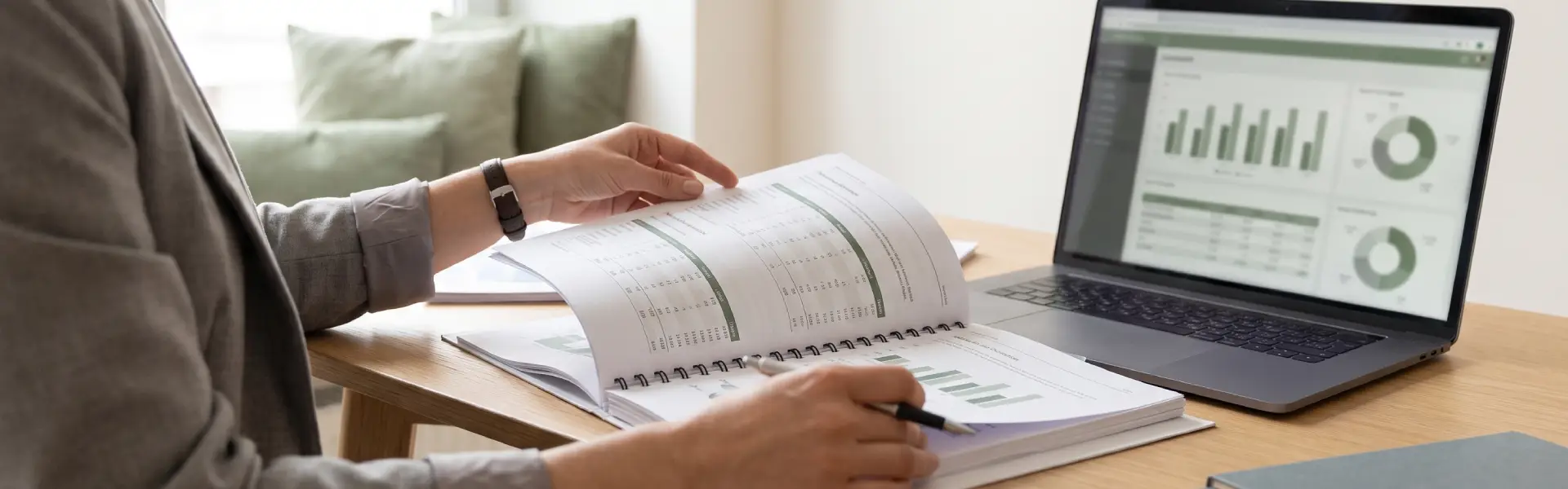 Professional reviewing Sustainability Accounting Standards Board disclosure reports alongside a dashboard on a laptop.